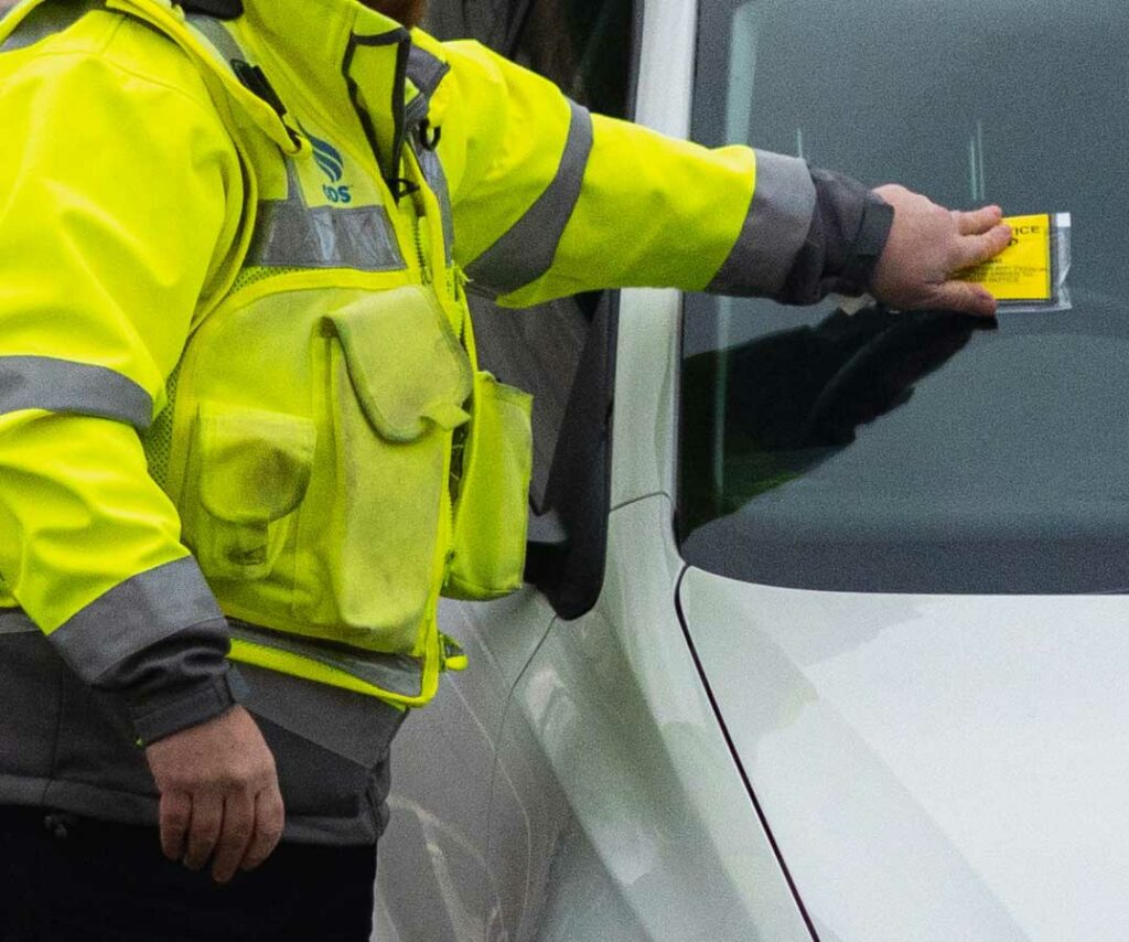 Penalty Charge Notice being issued on car windscreen