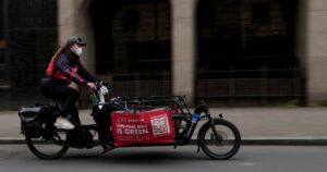 Pedal Me cargo bike rider with red banner and FORS sticker