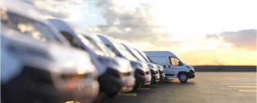 Fleet of parked vans in a row at sunset